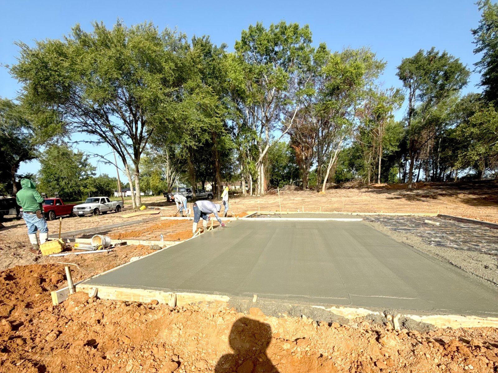 Concrete finishing work — SMG Concrete crew troweling a foundation slab in Tyler TX